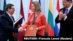 Bruno Rodríguez, saluda a la entonces jefa de política exterior de la UE, Federica Mogherini, junto al canciller de Eslovaquia, Miroslav Lajcak, luego de firmar el Acuerdo de Diálogo Político y Cooperación UE-Cuba en Bruselas, el 12 de diciembre de 2016. REUTERS/Francois Lenoir