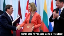 Bruno Rodríguez, saluda a la entonces jefa de política exterior de la UE, Federica Mogherini, junto al ministro de Relaciones Exteriores de Eslovaquia, Miroslav Lajcak, luego de firmar un Acuerdo de Diálogo Político y Cooperación UE-Cuba en Bruselas, el 12 de diciembre de 2016.