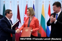 Bruno Rodríguez, saluda a la entonces jefa de política exterior de la UE, Federica Mogherini, junto al ministro de Relaciones Exteriores de Eslovaquia, Miroslav Lajcak, luego de firmar un Acuerdo de Diálogo Político y Cooperación UE-Cuba en Bruselas, el 12 de diciembre de 2016.