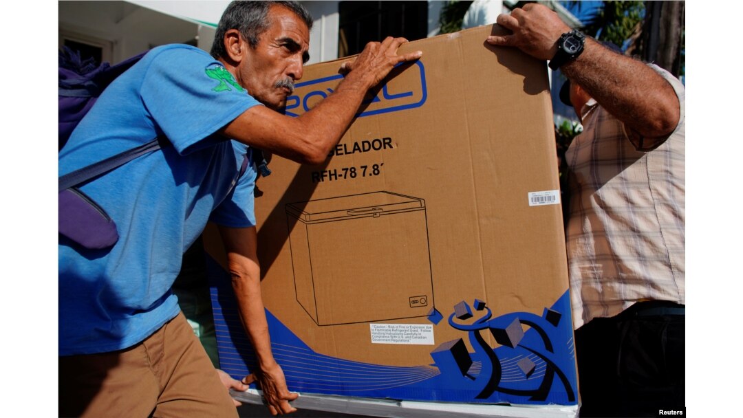 El chofer Héctor Castro carga un refrigerador comprado el lunes en una de las tiendas en La Habana (Foto: Alexandre Meneghini/Reuters).