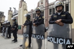Policías peruanos montan guardia frente a una instalación policial en Lima donde Keiko Fujimori permanece bajo arresto.