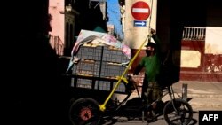Un hombre transporta pan en un triciclo en una zona en cuarentena por COVID-19 en La Habana. (YAMIL LAGE / AFP)