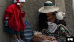 Una niña campesina junto a su madre piden limosna en las calles de La Paz (Bolivia). 