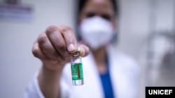 Una enfermera en Nueva Delhi muestra una ampolleta de la vacuna COVID-19. (Unicef/Sujay Reddy).