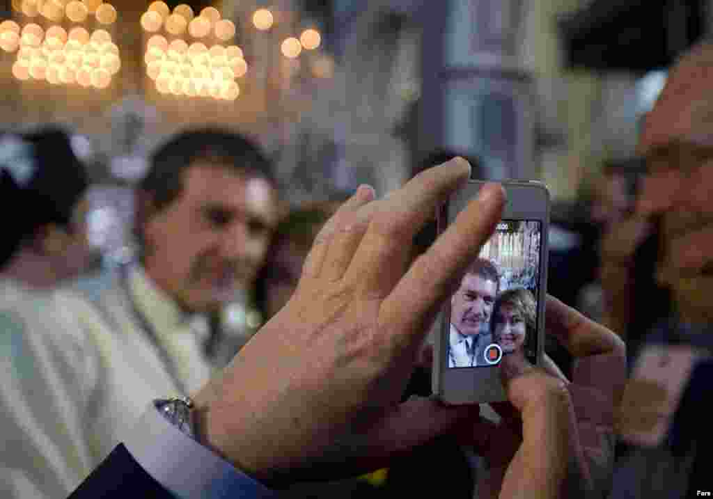 Un hombre fotografía con un móvil al actor Antonio Banderas antes de la procesión del Domingo de Ramos. 