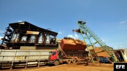 Obreros descargan un camión cargado con caña de azúcar en un central en Calimete, provincia de Matanzas.