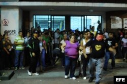 Seguidores del Gobierno venezolano y opositores se enfrentan en las puertas de un centro de votación hoy, domingo 14 de abril de 2013, en Caracas (Venezuela), luego de que el Consejo Nacional Electoral (CNE) oficializó el cierre de los colegios utilizados