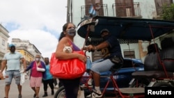 Una mujer con su gato en la bolsa en una calle de La Habana, en medio del peor rebrote de COVID-19 que ha vivido la capital. REUTERS/Stringer