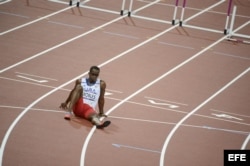 El cubano Dayron Robles se sienta en la pista en frustración por no terminar la prueba de los 110 metros vallas masculino.