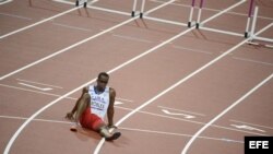 El cubano Dayron Robles se sienta en la pista en frustración por no terminar la prueba de los 110 metros vallas masculino. 
