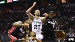 El jugador de los Heat LeBron James (d) atrapa un rebote ante Tony Parker (2-i) y Manu Ginobili (2-d) de los Spurs el jueves 13 de junio de 2013, durante el cuarto juego de la serie final de la NBA en el AT&T Center en San Antonio (EE.UU.).
