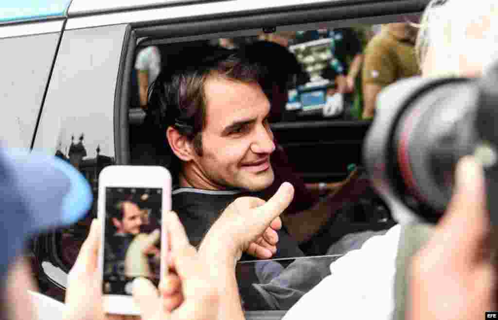 Los admiradores de Roger Federer siguen al campeón suizo hasta su vehículo. Lo felicitan y le toman fotos.
