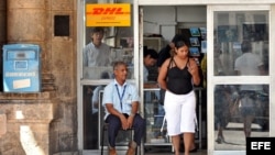 Un empleado estatal custodia la puerta de una oficina de correos en La Habana. 