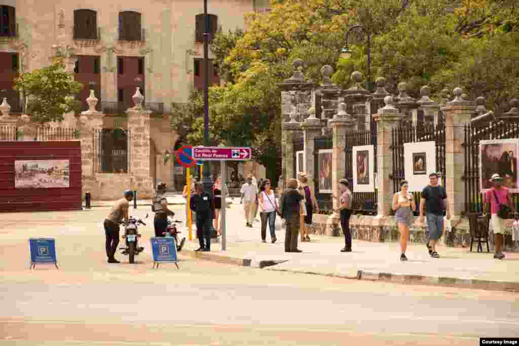Policía inquiere a un transeúnte en la Habana Vieja.