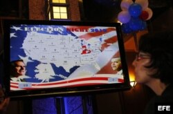 Una mujer observa una transmisión televisiva de los resultados electorales.