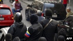 Miembros enmascarados de un "colectivo" pro gubernamental patrullan las calles de Caracas.