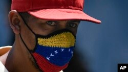 Un hombre viste una mascarilla con la bandera de Venezuela en una calle de Caracas. (AP/Matias Delacroix)