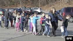 Fotografía cedida que muestra a unos agentes de policía evacuando a unos niños de la escuela Sandy Hook en Newtown, Connecticut.