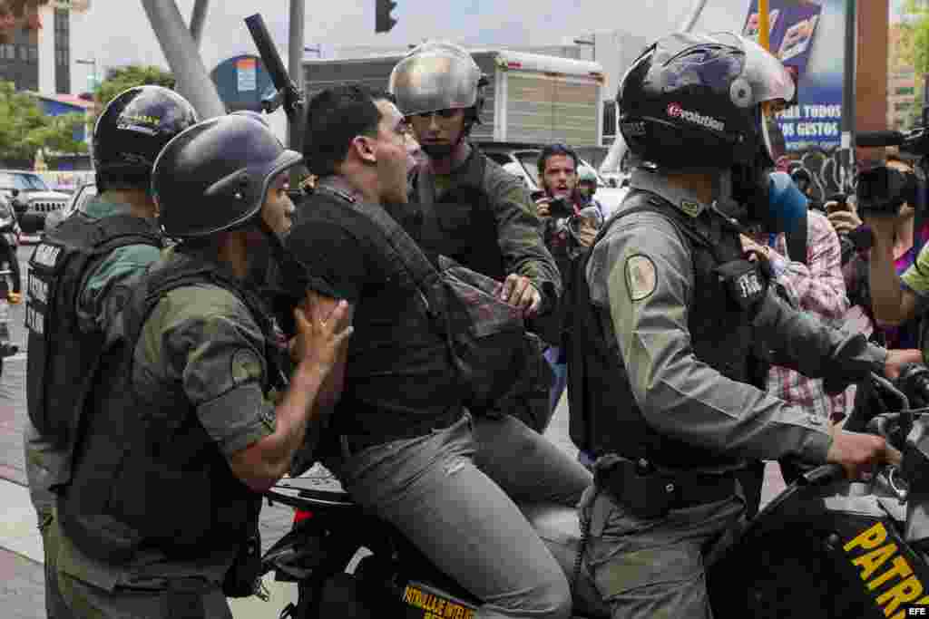 Miembros de la Guardia Nacional Bolivariana detienen a un manifestante durante una marcha de opositores.