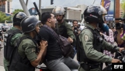 Miembros de la Guardia Nacional Bolivariana detienen a un manifestante durante una marcha de opositores.