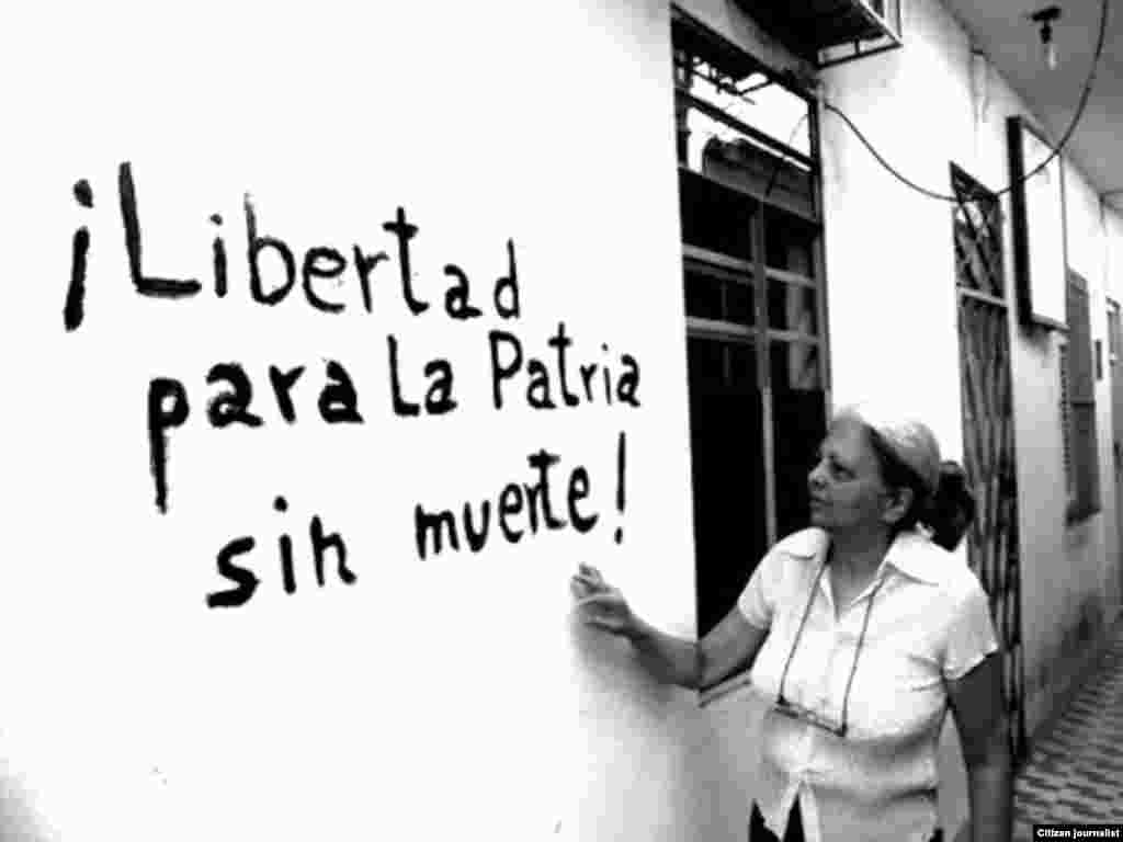La disidente Martha Beatriz Roque mostrando una pintada en su casa. Actualmente preside la Red Cubana de Comunicadores Comunitarios.