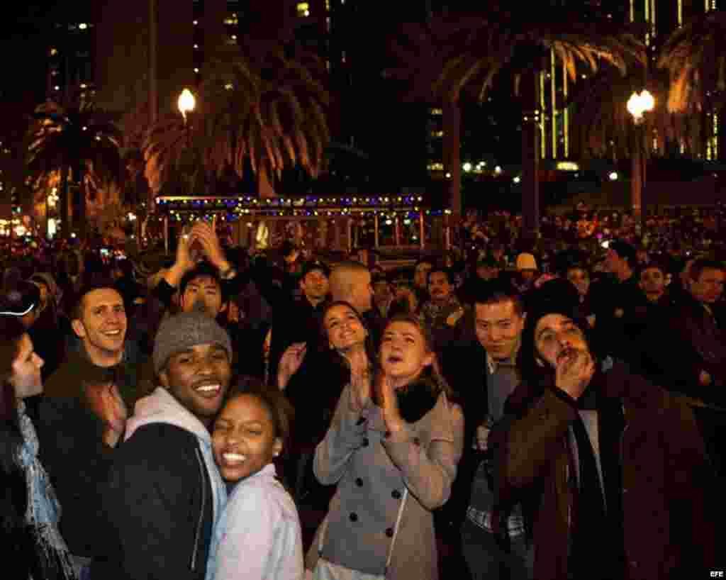 Una multitud celebra la llegada del nuevo año mientras disfruta del espectáculo de fuegos artificiales en San Francisco, Estados Unidos.