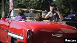 Un turista toma fotos desde un carro en La Habana.