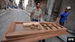 Un carpintero carga varias puertas en una carretilla en La Habana (Cuba).