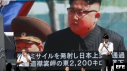 Los peatones caminan bajo un monitor a gran escala que muestra al líder norcoreano Kim Jong-un en una emisión de noticias de televisión hoy, viernes 15 de septiembre de 2017, en Tokio (Japón)