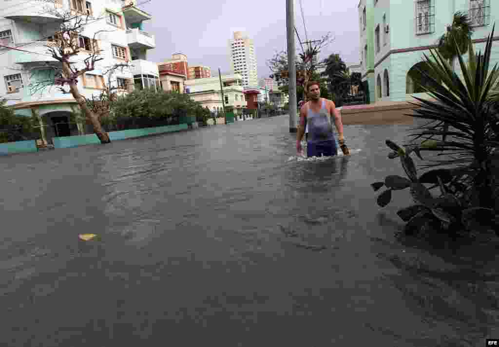 Un hombre camina por una calle inundada por las penetraciones del mar hoy, sábado 23 de enero de 2016, en La Habana (Cuba). EFE/Alejandro Ernesto
