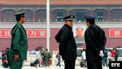 Archivo - Policías vigilan las entradas y salidas en la plaza de Tiananmen, en Pekín, China.