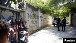 Periodistas interrogan a oficiales de Policía que rodean la residencia del presidente asesinado, Jovenel Moise, en Puerto Príncipe, Haití. (REUTERS/Estailove St-Val)