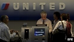 Pasajeros facturan para su vuelo en un mostrador de United Airlines.