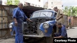 Varios cubanos arreglan un automóvil clásico estadounidense. Foto: Discovery.