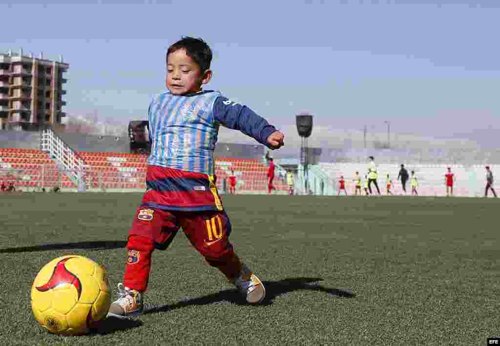 El niño afgano de 5 años, Murtaza Ahmadi, un joven seguidor del delantero argentino del FC Barcelona Lionel Messi, juega con una camiseta de la selección nacional argentina firmada por el astro argentino en Kabul (Afganistán).