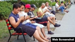 Varias personas se conectan a internet en un parque de Santa Clara.