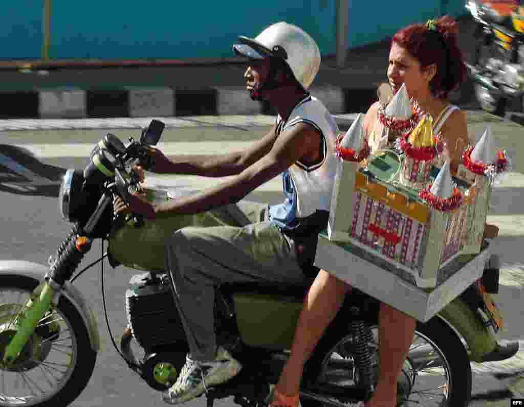 Una mujer viaja en una moto-taxi particular por las calles de Santiago de Cuba.