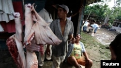 Campesinos venden carne de cerdo en una granja en las afueras de La Havana (Desmond Boylan / Reuters).