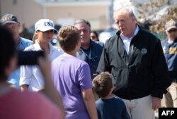 El presidente Donald Trump y la primera dama Melania Trump conversan con sobrevivientes del huracán Michael en Lynn Haven, Florida.