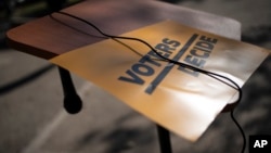 Un cartel reza: "Los votantes deciden". (AP Photo/Wong Maye-E)
