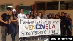 Jóvenes posan con el cartel "Mamá me fui a luchar por Venezuela"