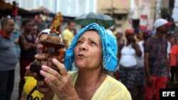 Una devota reza durante una peregrinación con la imagen de la Virgen de la Caridad del Cobre, patrona de Cuba, por las calles de un céntrico barrio de La Habana. Foto Archivo. 