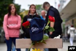 Una gorra con el cartel de "Cuba""cuelga sobre una cruz conmemorativa de Daniel H, el cubano alemán asesinado en Chemnitz, Alemania cuya muerte desató multitudinarias protestas.