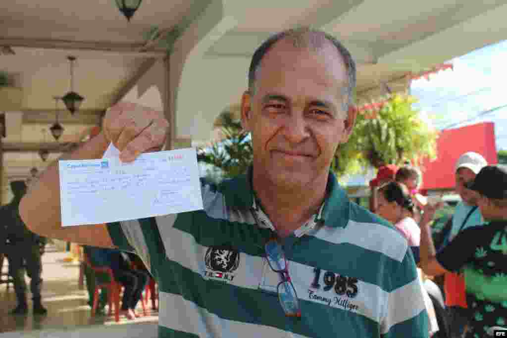 El cubano Diego Domínguez muestra el recibo de pago de su boleto de avión, por 523.50 dólares, para viajar a México.
