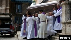 Miembros del clero cargan el ataúd con los restos del cardenal Jaime Ortega Alamino. 