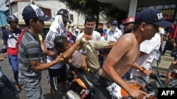 Los manifestantes venezolanos cargan a un manifestante lesionado en una motocicleta durante una protesta en la ciudad fronteriza de Urena, Tachira, después de que el gobierno del presidente Nicolás Maduro ordenara un cierre temporal de la frontera con Col