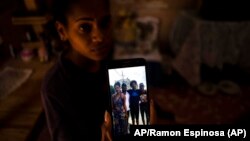María Carla Milán Ramos muestra una foto en su teléfono de su esposo y sus hermanos, todos en prisión por participar en las protestas del 11 de julio del 2021. 