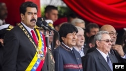 El presidente de Venezuela, Nicolás Maduro (i), acompañado por sus pares de Cuba, Raúl Castro (d), y de Bolivia, Evo Morales (c), durante el desfile militar para conmemorar el primer aniversario del la muerte del fallecido mandatario venezolano Hugo Cháve