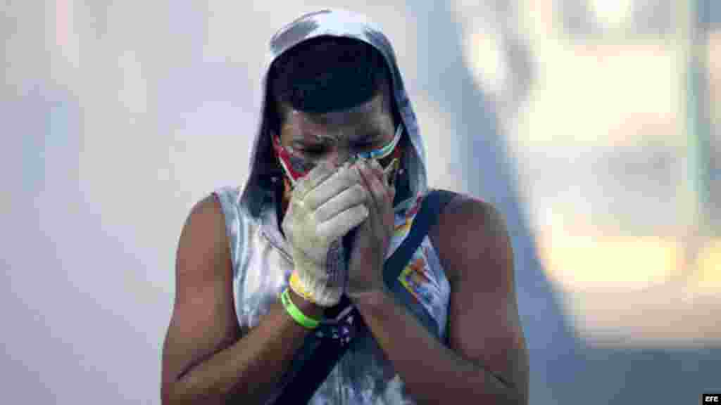 Participante de la protesta contra el Gobierno de Nicolás Maduro intenta evitar los gases lacrimógenos.
