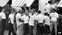 Un grupo de cubanos esperan entrar en una casa de Miami para alistarse y luchar contra Castro, el 18 de abril de 1961.